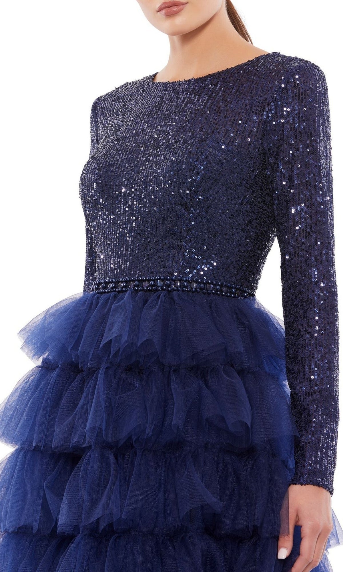 A woman models the Mac Duggal 26299 knee-length wedding guest dress in navy blue sequins, featuring long sleeves and a tiered tulle skirt; her face is partially obscured.